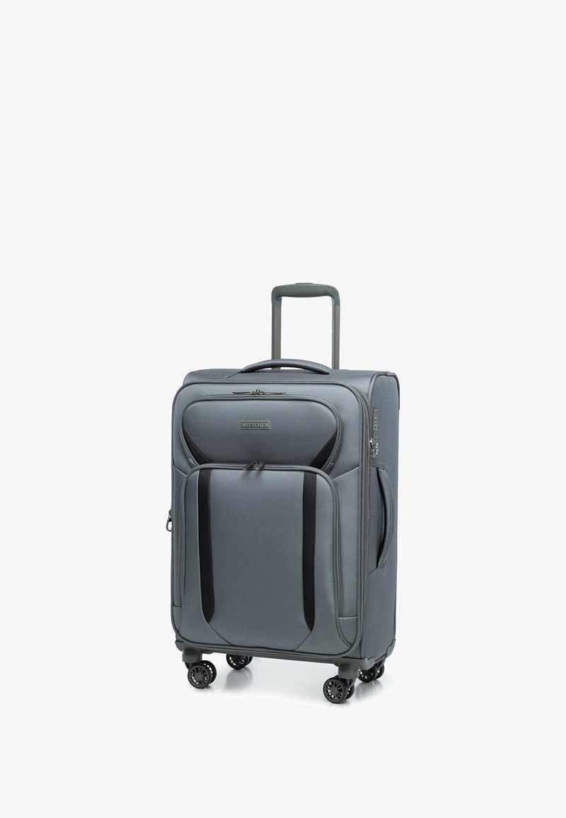 Valise souple grise avec poches avant, quatre roues pivotantes, poignée rétractable et poignée de transport latérale, se tenant debout sur fond blanc.