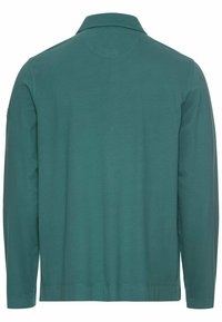 Langærmet polo-shirt lavet af teal bomuldsstof, med krave, lige nederste kant og ingen synlige mønstre eller detaljer.