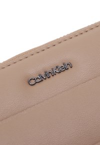 Calvin Klein LINE QUILT LARGE ZIP AROUND - Lompakko - chanterelle