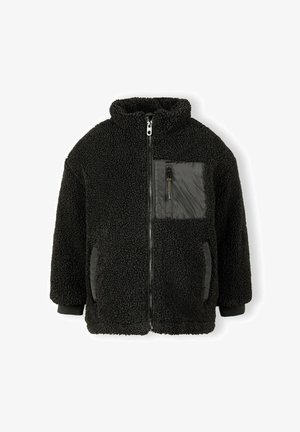 Črna flis jakna z zadrgo spredaj, visokim ovratnikom in sprednjo žepom. Opremljena je z gladkimi črnimi tkaninami na žepu in stranskih šivih.