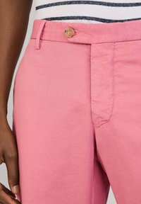Rosa Baumwollhosen mit Knopfverschluss, taillierter Passform und glatter Textur. Der Bund enthält Gürtelschlaufen und Nähte.
