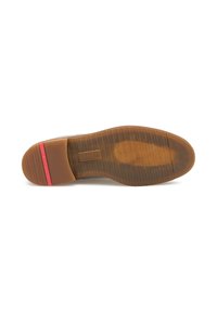 Suola in gomma marrone con scanalature orizzontali, tacco tan texturizzato e una striscia di accento rossa; design pulito senza loghi o motivi visibili.