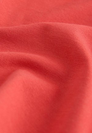 Koralová látka s hladkou texturou, zdobená jemnými diagonálními žebrovými vzory. Materiál působí měkce a lehce.