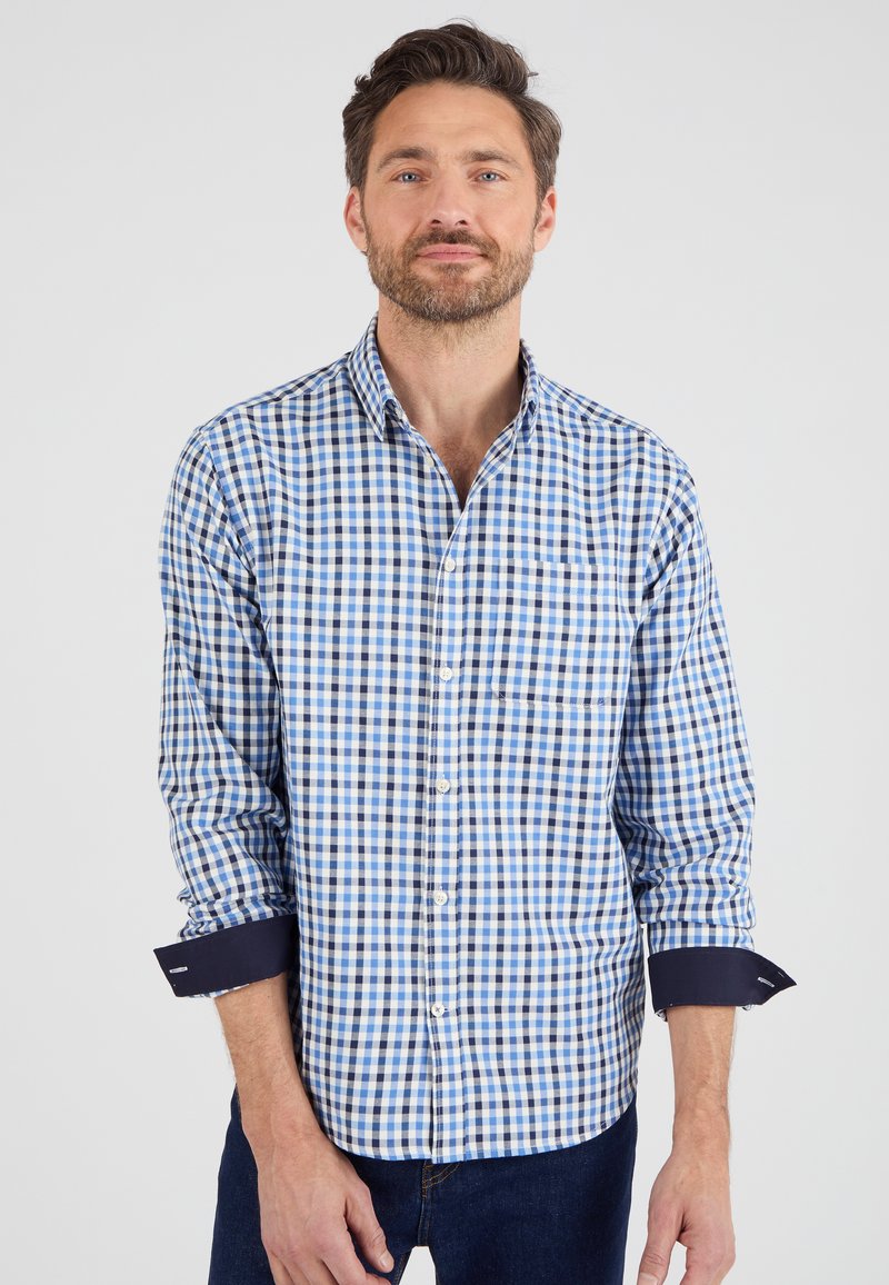 Camicia a quadri button-up in cotone blu e bianco con polsini blu navy e taschino sul petto. Presenta un colletto classico e maniche lunghe.