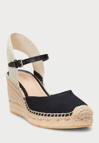 Crne platnene espadrile sa wedge petom, s wovanim off-white remenom oko gležnja, detaljima od jute na đonu i zaobljenim nožnim prstima. Kaiš se zatvara kopčom.