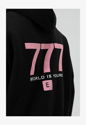 Schwarzer Hoodie mit großem pinkfarbenem "777"-Aufdruck auf dem Rücken, darunter "WORLD IS YOURS" in Weiß und ein kleines pinkfarbenes Quadrat mit einem "E". Mit strukturiertem Akzent.