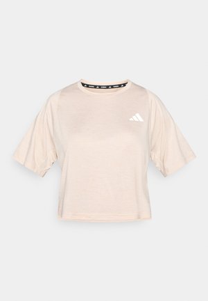 T-shirt corta a maniche corte, color beige chiaro, tagliata sopra la vita, realizzata in tessuto morbido. Presenta una fascia con logo nero sul collo e un logo bianco sul lato sinistro.