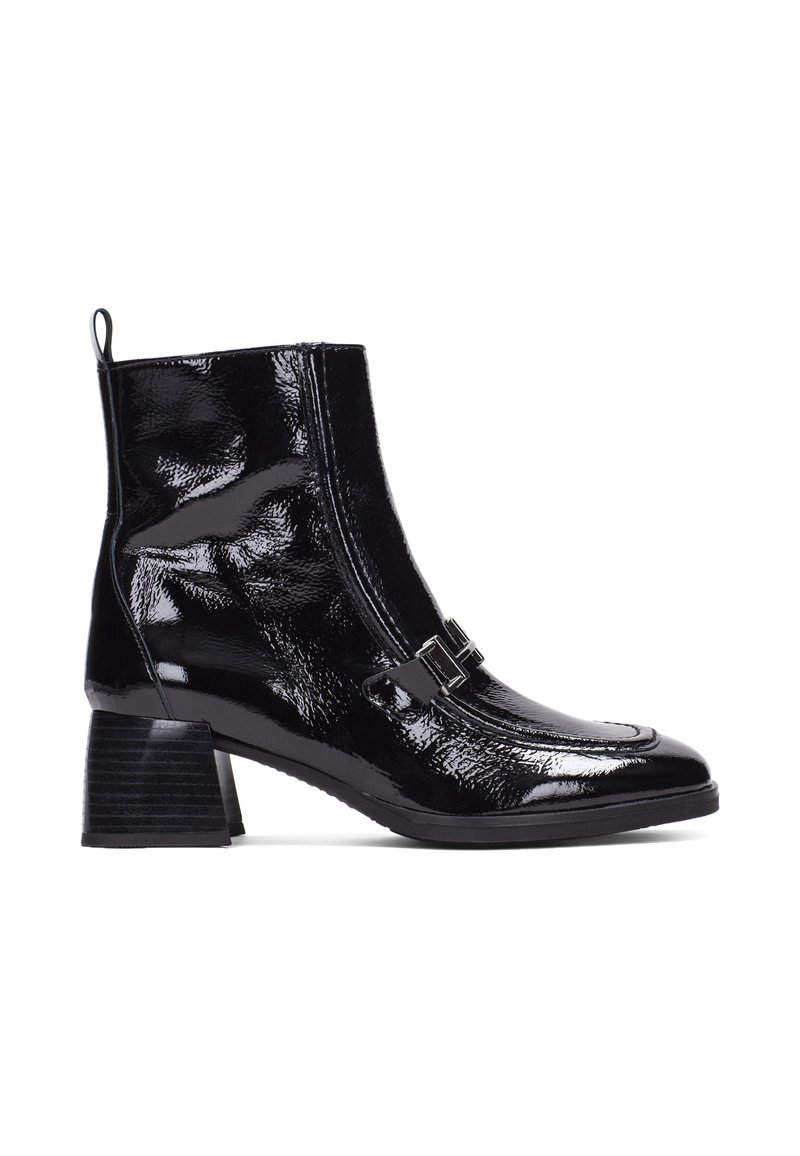 Botín de charol negro con un diseño elegante, puntera cuadrada, cremallera lateral y una hebilla decorativa. Presenta un tacón apilado.