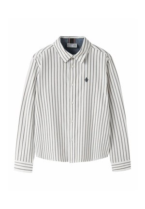 Chemise blanche à manches longues et boutonnée, avec de fines rayures verticales grises, un col pointu et un petit écusson sur la poitrine.