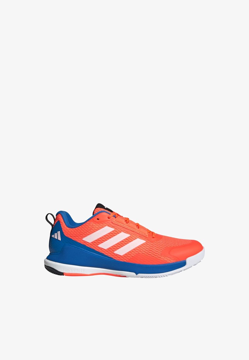 Urheilukenkä, jossa on kohokuvioitu oranssi päällinen ja sininen pohja. Ominaisuuksiin kuuluvat kolme valkoista raitaa, mustat yksityiskohdat ja pyöreä varv Design.