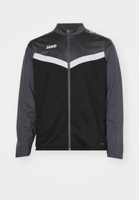 Zwarte en donkergrijze sportjack met hoge kraag, ritssluiting aan de voorkant en witte chevron-details. Voorzien van een textuur op de schouders.