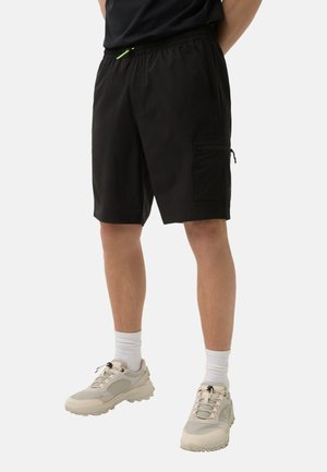 Zwarte cargoshorts met elastische tailleband, zijzakken en een neon trekkoord. Draag ze met lichtgekleurde sneakers en witte enkelsokken.
