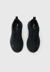 Juodi atletiniai bateliai su tinklelio viršumi, apvalia nosimi, plokščiu padu ir raišteliais. Ant liežuvėlio ir šono yra logotipas, skiriantis prekės ženklą.