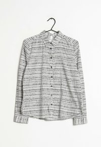 Camisetta a maniche lunghe a motivi bianchi e neri con colletto, bottoni sul davanti e orlo dritto. Tessuto testurizzato.