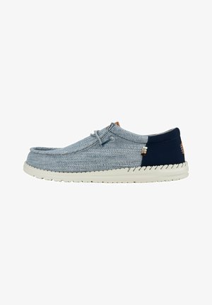 Scarpa slip-on in tessuto azzurro chiaro con accento blu navy, suola in gomma, punta rotonda e dettaglio di laccio semplice. Presenta un upper testurizzato.