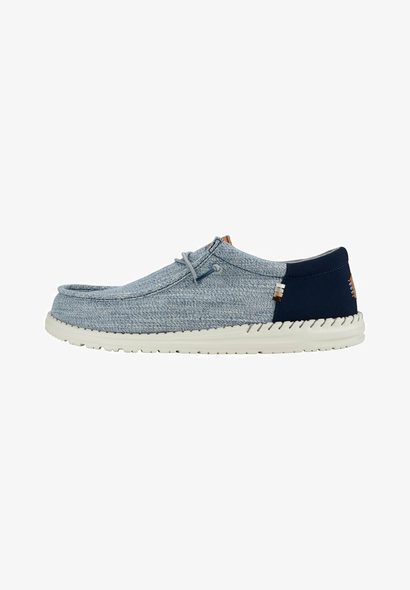 Scarpa slip-on in tessuto azzurro chiaro con accento blu navy, suola in gomma, punta rotonda e dettaglio di laccio semplice. Presenta un upper testurizzato.