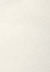 Strickstoff in heller Cremefarbe, mit einer glatten Textur und einem feinen, gleichmäßigen Muster. Keine sichtbaren Muster oder Akzente.