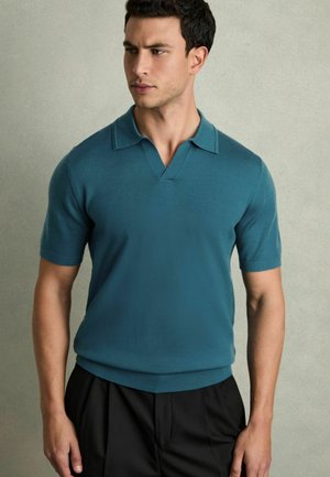 Teal, short-sleeve polo shirt with a V-neck and two-button placket; crafted from soft fabric; paired with black trousers.