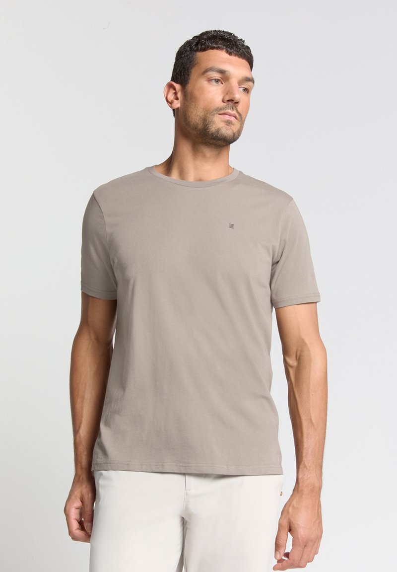 Korte mouwen, ronde hals t-shirt in taupe katoenmix, met een klein logo op de borst. Glad oppervlak en normale pasvorm.