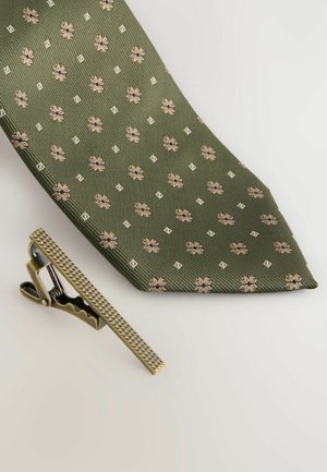 Grüne Krawatte mit gerippter Textur, verziert mit kleinen Blumen- und geometrischen Mustern in Gold und Creme. Enthält einen goldenen Krawattenclip im Vintage-Stil.