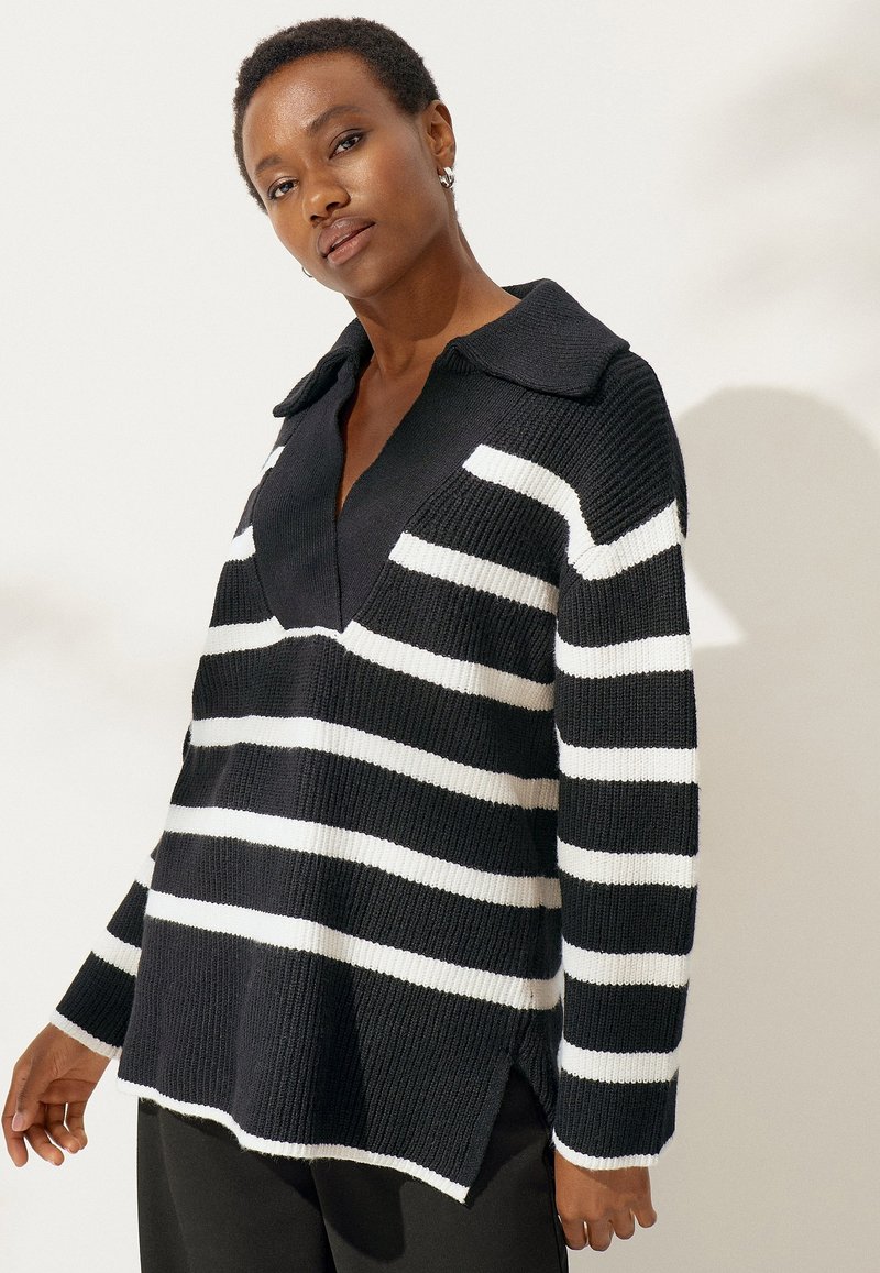 Zwart-witte gestreepte gebreide trui met een kraag, V-hals, zijsplitsen en geribbelde textuur. Lange mouwen, casual pasvorm.