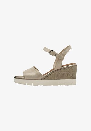 Wedge sandal in beige with a smooth upper, open toe, ankle strap with buckle, and textured wedge heel featuring a light-colored rubber sole.