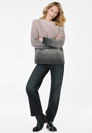 Pull en peluche avec un dégradé allant du rose clair au gris foncé, associé à un jean en denim foncé et des bottines noires. Texture douce, encolure ronde.