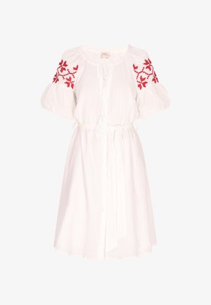 Fehér ruha puffos ujjal és vörös hímzett mintákkal a vállakon. Húzózsinórral készült derékrész és bojtos részlet jellemzi.