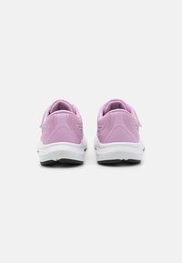 Des chaussures de sport violettes avec une tige texturée, une semelle blanche et une semelle extérieure noire. Le système de fermeture comprend une sangle à crochet et à boucle.