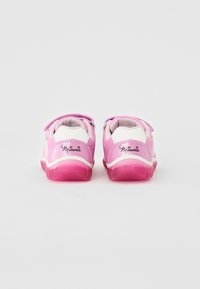 Pink children's shoes with white accents, velcro straps, and textured rubber soles. Features "Minnie" logo on the heels.