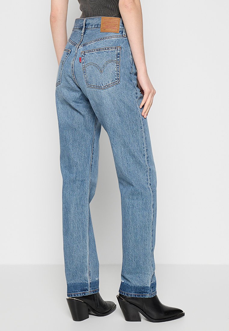 Jeans in denim azzurro chiaro con un design a gamba dritta, dotati di tasche posteriori, una patch in pelle con logo e una finitura leggermente sbiadita.
