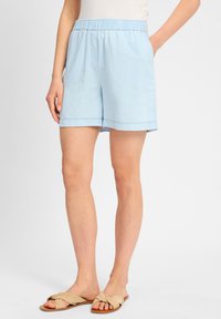 Lichtblauwe katoenen shorts met een elastische tailleband, zijzakken en een relaxte pasvorm. De zoom is afgewerkt met een nette steek.