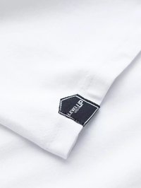 Hvid bomulds-T-shirt med en foldet ærme, der viser et sort sekskantet mærke med "LEVEL UP" i hvid tekst og kontrasterende syninger.