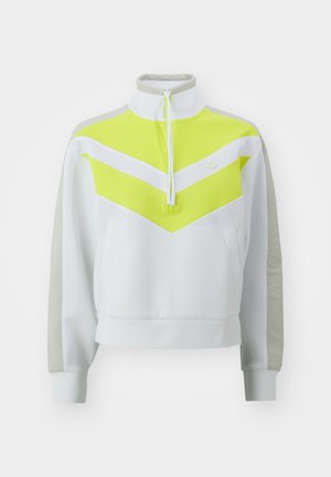 Felpa bianca a zip con un design a chevron giallo brillante. Presenta maniche grigie e una tasca a marsupio. Tessuto morbido e vestibilità atletica.