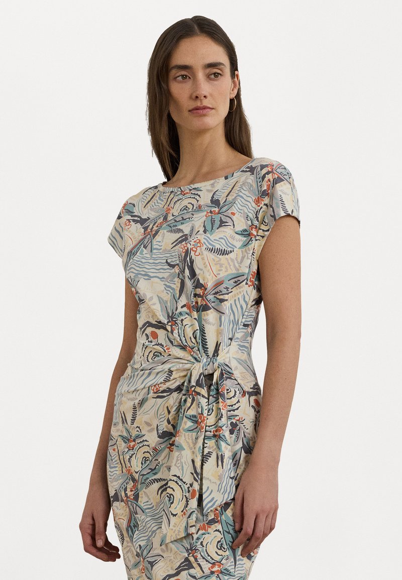 Vestido com padrão floral em tecido leve, apresentando mangas curtas, decote barco e detalhe de cintura com nó em cores suaves.