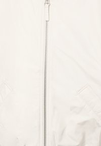 White bomber jacket featuring a central silver zipper, side pockets, and a smooth, matte finish with subtle stitching details.
