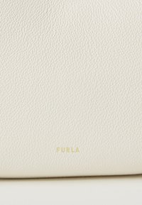 Mala de mão em couro branco texturizado com grão subtil, apresentando um logótipo "Furla" em relevo dourado na parte inferior. Design simples e elegante.