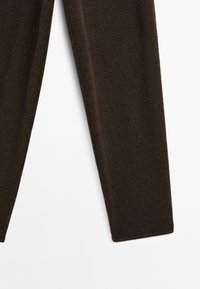 Leggings marron fabriqués à partir d'un tissu doux et texturé. Le design présente une coupe ajustée avec une finition lisse et un ourlet droit au niveau des chevilles.