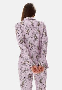 Purple pajama set featuring a leopard print pattern with black spots and metallic accents. Long sleeves and relaxed fit with a classic collar.