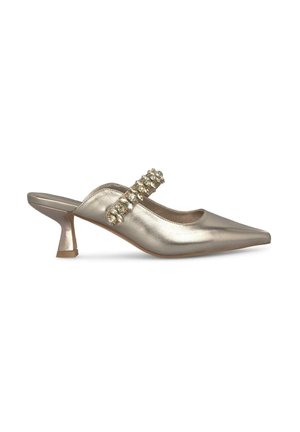 Mule con tacco basso in oro metallico con punta affilata, dotate di una cinghia decorativa di gioielli che attraversa il piede.