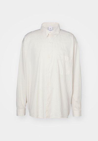 Lys beige skjorte med knapper laget av bomull, med klassisk krage, lange ermer og en enkelt brystlomme. Jevn tekstur.