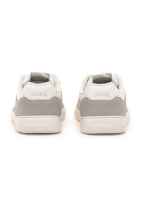 Un paio di sneakers basse grigio e bianche con il logo "mtng." sul tallone, mostrate da dietro su uno sfondo bianco.