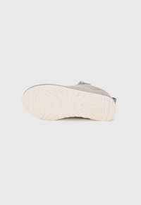 Scarpa di tessuto grigio con una parte superiore testurizzata, abbinata a una spessa suola in gomma bianca con un motivo a zig zag.
