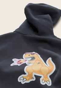Felpa nera con cappuccio caratterizzata da una grande grafica di un dinosauro cartone animato arancione, che indossa occhiali da sole e sputa fuoco, aggiungendo un dettaglio giocoso al design.