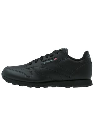 Sort læder Reebok sneaker med snøredesign, tekstureret sål og lille Union Jack-logo på siden.
