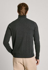 Maglione grigio scuro a collo alto, realizzato in materiale morbido, presenta maniche lunghe e orlo a coste. La vista posteriore mostra un design aderente.