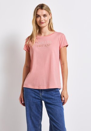 T-shirt en coton rose à manches courtes et col rond. Présente un texte blanc et doré "ENDLESS DREAM" dans une police décontractée.