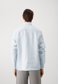 Helles blau gestreiftes Hemd mit langen Ärmeln, knöpfbaren Manschetten und klassischem Kragen. Der Stoff zeigt eine feine Textur.