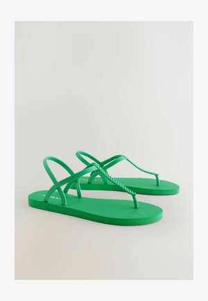 Zielone klapki zrobione z gumy, z teksturowaną wkładką, plecionym paskiem na palce oraz podwójnymi paskami krzyżującymi się. Prosta sylwetka bez ozdób.