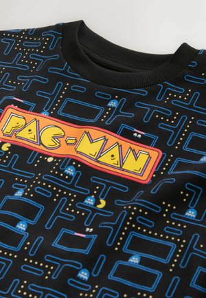 Schwarzer Pullover mit farbenfrohem "PAC-MAN"-Grafikdesign mit Labyrinthmustern, blauen Geistern und gelben Punkten auf weichem Material.